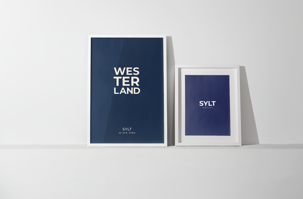 Beide Postergrößen, A3 und 50 x 70 cm, stehen nebeneinander an die Wand gelehnt, um den Größenunterschied der Formate und die gemeinsame Wirkung zu zeigen. 