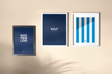 Das Sylt Typografie-Poster in der Mitte einer gerahmten Dreierhängung mit den Sylt Postern Westerland und Strandkorbstreifen aus der Launch Kollektion. 