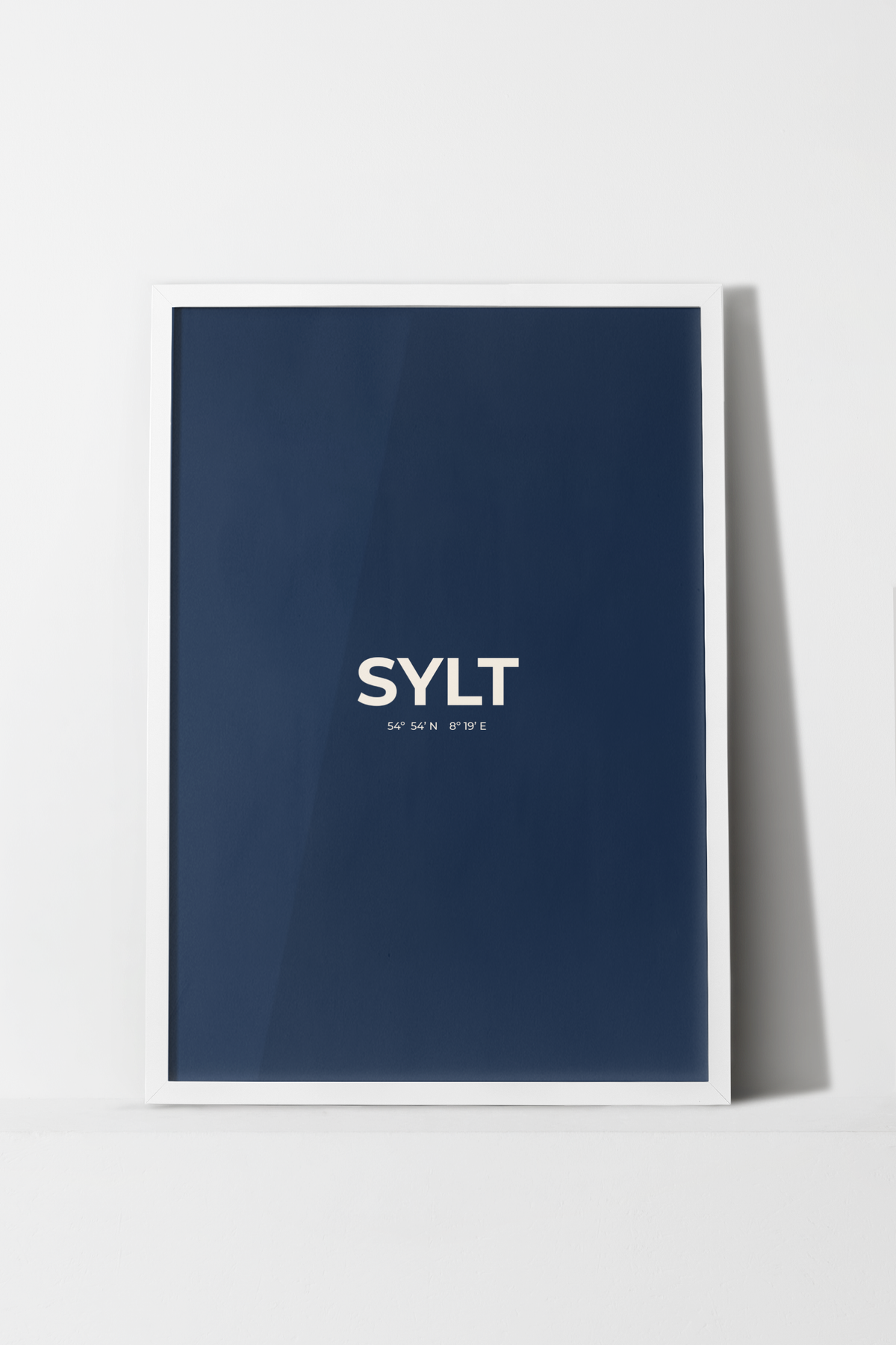 Sylt Poster in Dunkelblau mit creme-weißer Typografie „SYLT“ und geografischen Koordinaten darunter.